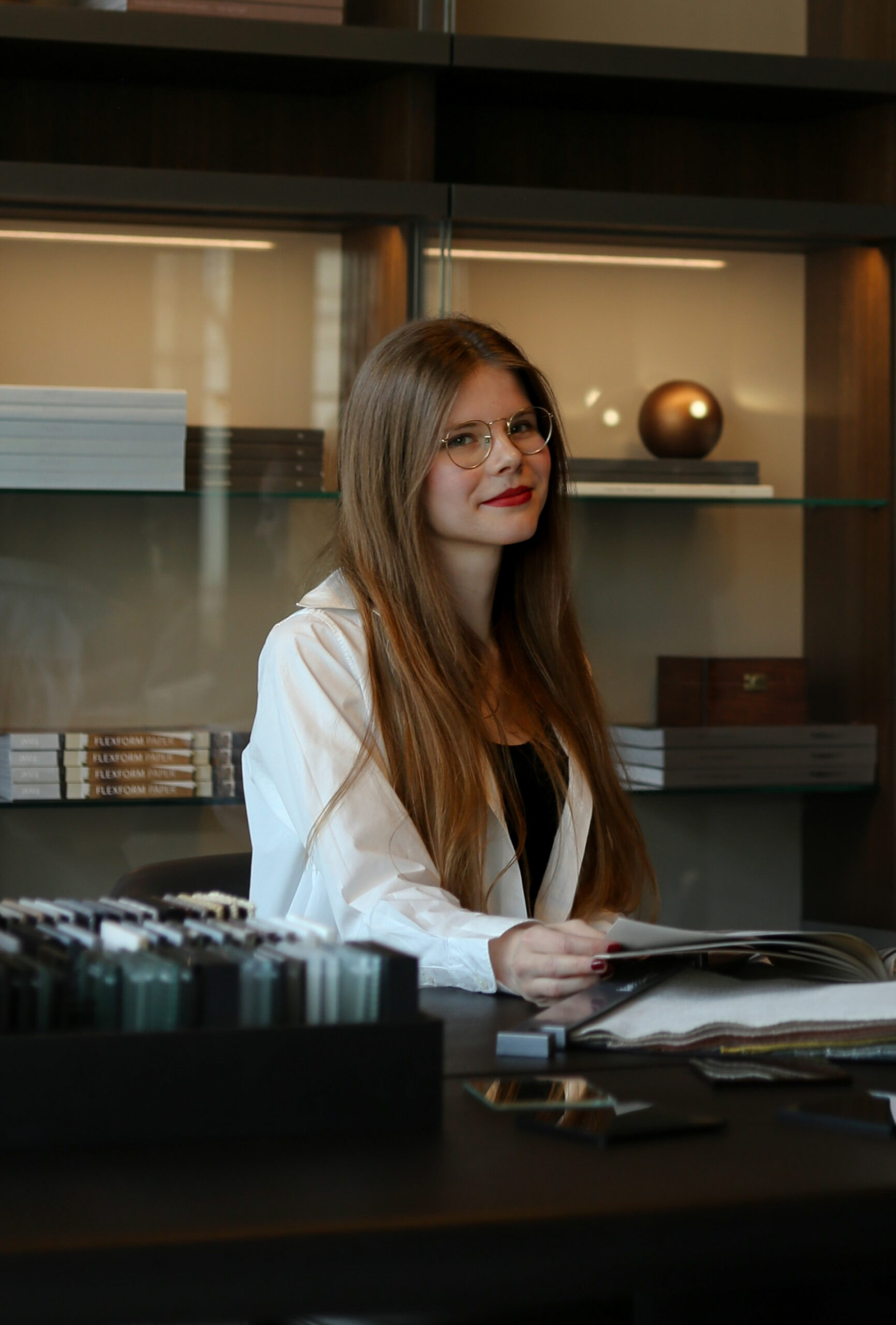 Siedząca przy stole Zuzanna Rogowska architekt wnętrz oraz artystka 3D w firmie Bergamot Interior Design
